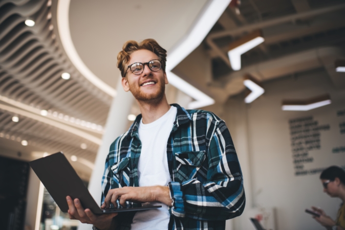 Young smiling bearded successful man in glasses