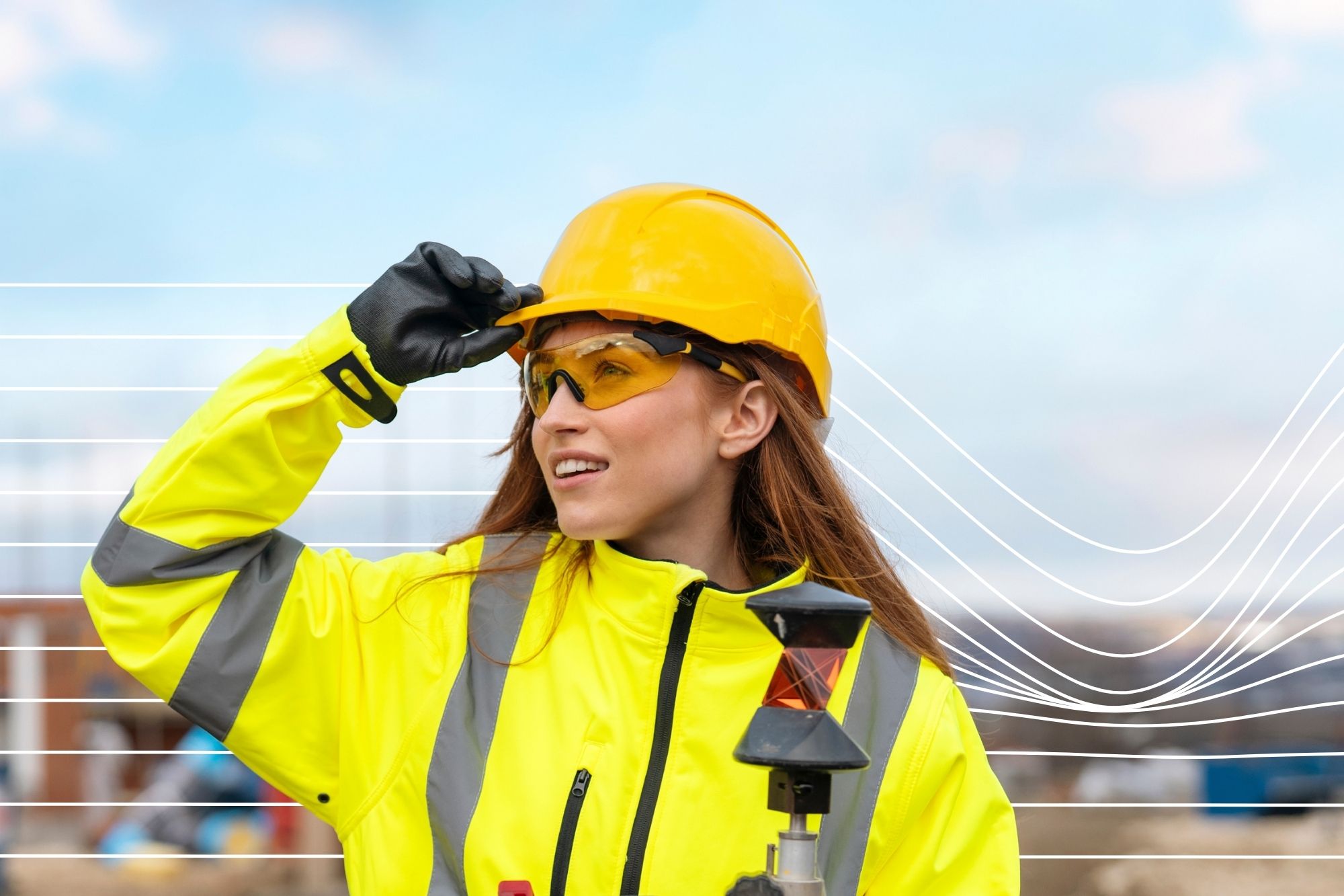 Portrait of smiling young woman builder surveyor in bright safety gear using rugged tablet at construction site
