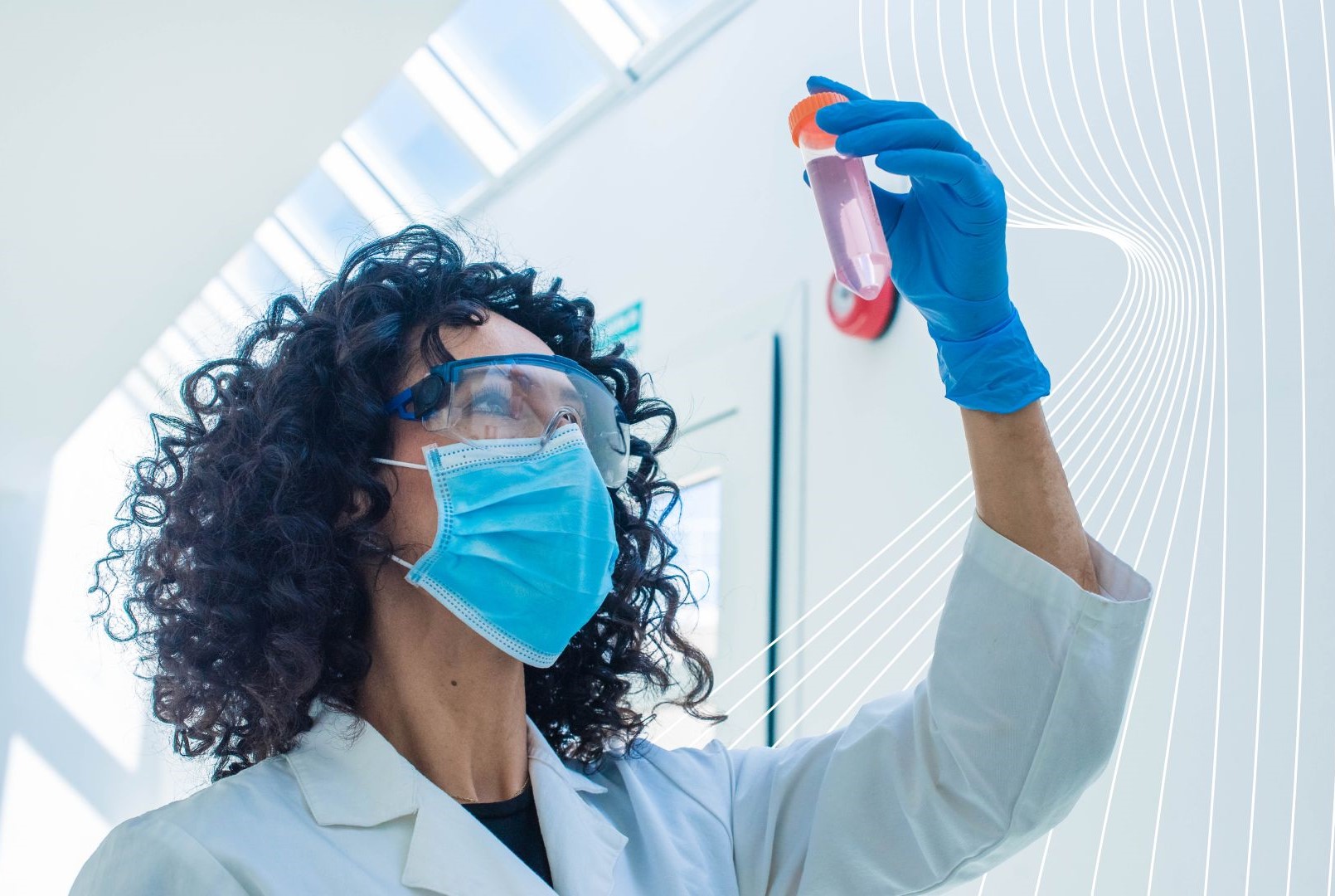 Radiochemist in a white lab coat and blue gloves examines a test tube with pink liquid in a sunlit, modern laboratory, highlighting precision and analytical focus in radiochemistry.