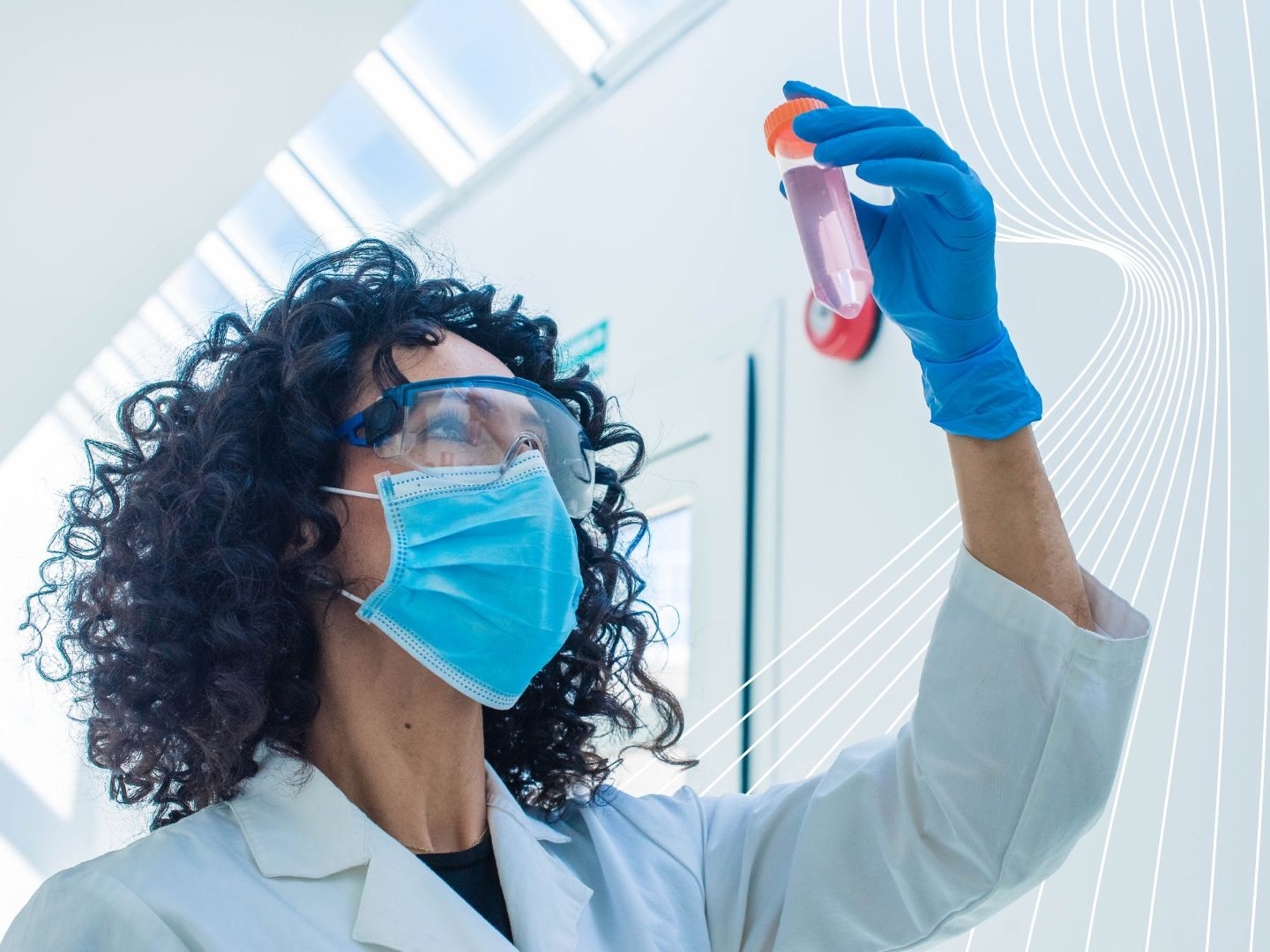 Radiochemist in a white lab coat and blue gloves examines a test tube with pink liquid in a sunlit, modern laboratory, highlighting precision and analytical focus in radiochemistry.